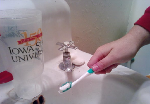 Person brushing their teeth and turning the water down