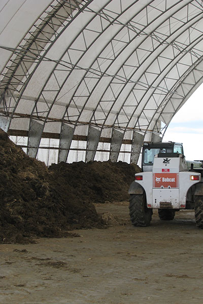 Compost being stirred at compost farm. 