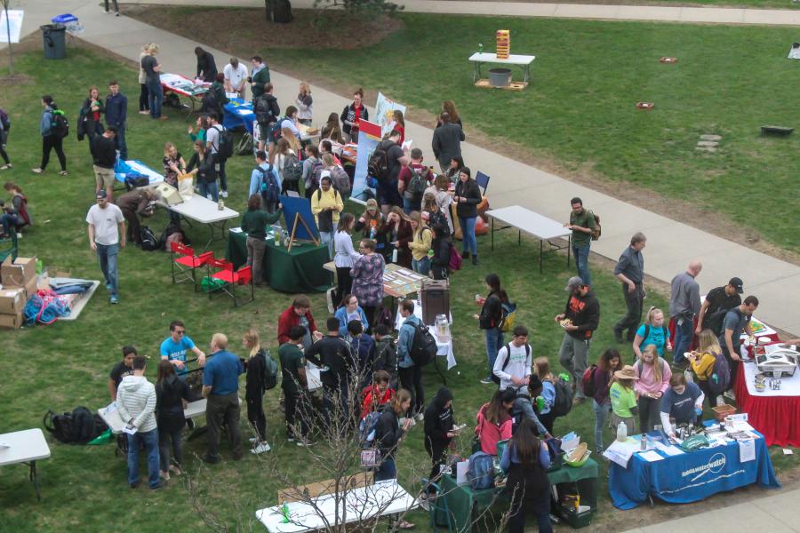 Students gather around tables and discuss sustainable topics at Celebrate Green event.